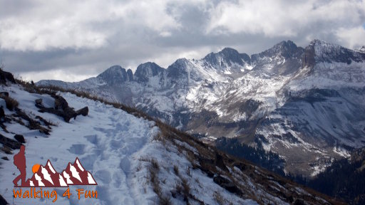 Dramatic, snow-covered mountains with a trail through the snow.