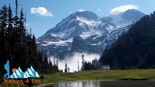 A glacial-covered Mount Rainier overlooking a small lake with mist in the distance